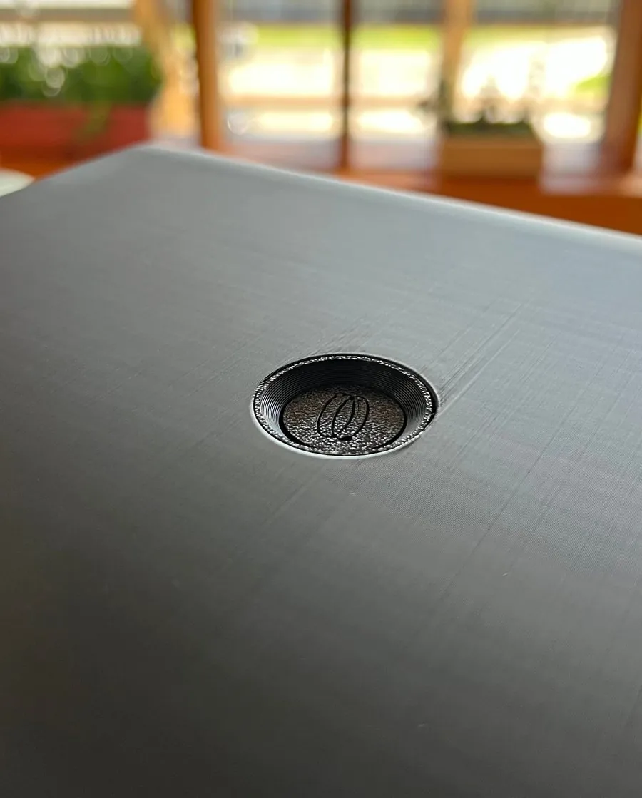 Close-up of the button on top of the Local AI Workstation, embossed with the Spaces mark.